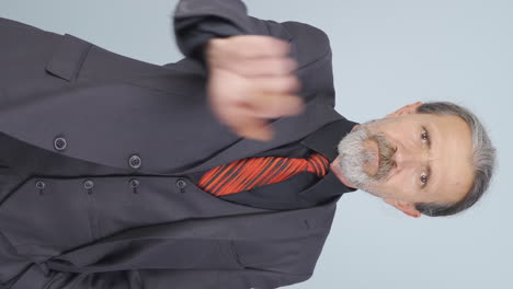 Vertical-video-of-Old-businessman-saying-stop-to-camera.